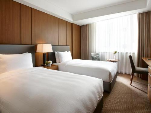 a hotel room with two beds and a desk at LOTTE City Hotel Guro in Seoul