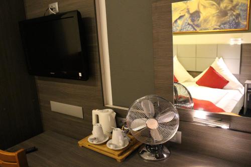 a room with a fan and a mirror and a bed at Rheinhotel Lilie in Boppard