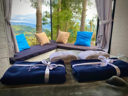 a room with three beds with blue pillows and a window at Tiny Houses Premium - Casa Barcelona in Duitama