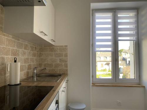 kuchnia ze zlewem i oknem w obiekcie Appartement rénové 5 personnes avec balcon au centre de Perros-Guirec - FR-1-368-382 w mieście Perros-Guirec