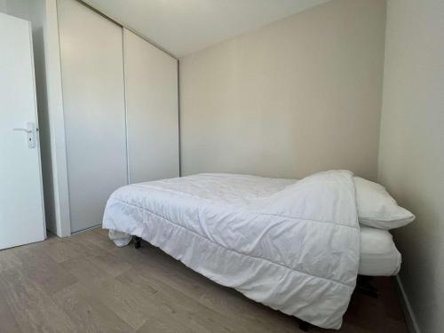 um pequeno quarto com uma cama com lençóis brancos em Appartement La Rochelle, 2 pièces, 4 personnes - FR-1-246-653 em La Rochelle