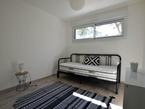 un salon avec un canapé et une fenêtre dans l'établissement Villa climatisée confort avec jardin, terrasse et WIFI à 300m commerces et 1km plages - 6 pers - FR-1-705-32, à La Palmyre