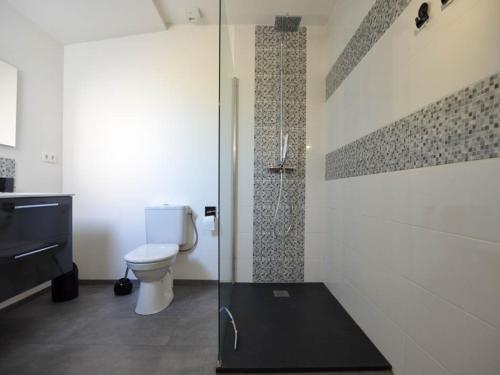 une salle de bain avec toilettes et douche en verre dans l'établissement Villa climatisée confort avec jardin, terrasse et WIFI à 300m commerces et 1km plages - 6 pers - FR-1-705-32, à La Palmyre