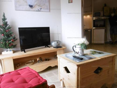 un salon avec une télévision et un arbre de Noël dans l'établissement Appartement T2 avec Mezzanine, 4 couchages, balcon, Chemin de Planés - FR-1-295-192, aux Angles