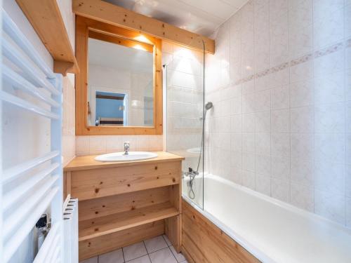 une salle de bain avec un lavabo, une baignoire et un miroir dans l'établissement Studio lumineux avec terrasse, skis aux pieds, Tignes Le Lac - FR-1-502-490, à Tignes