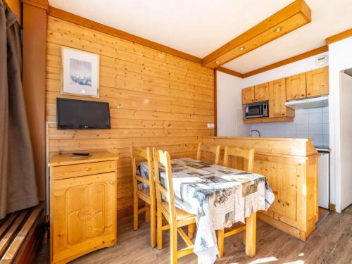 une cuisine et une salle à manger avec une table et des chaises dans l'établissement Studio rénové skis aux pieds à Tignes avec balcon, exposition sud, animaux acceptés - FR-1-502-491, à Tignes