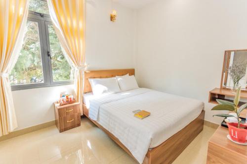 um quarto com uma cama branca e uma janela em Bách Tùng Viên Villa Đà Lạt em Ấp Kim Thạch