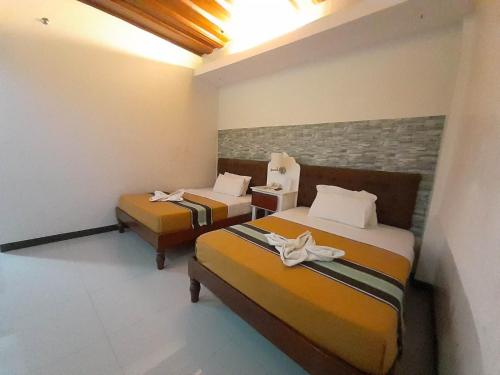 two beds in a hotel room with two beds at MelSol Hotel in Bantay