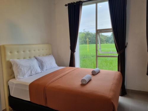 日惹Giori Rice Field View Syariah的一间带床的卧室，配有大窗户