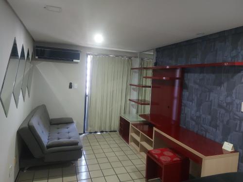 uma sala de estar com uma cadeira e uma prateleira em Flat Number One - Ponta D'areia - Ferreira Hospedagens em São Luís