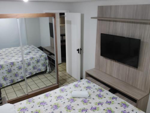 sypialnia z łóżkiem, telewizorem i lustrem w obiekcie Flat Number One Ponta DAREIA l Conforto, Estrutura l Ferreira Hospedagens w mieście São Luís