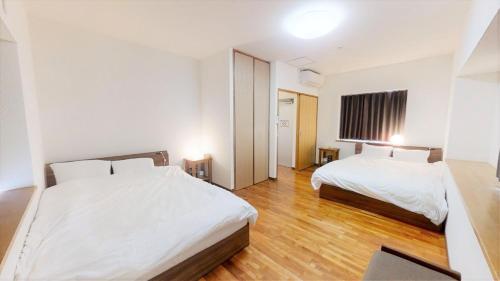 una habitación de hotel con 2 camas en una habitación en Suminchu House Ichariba en Naha