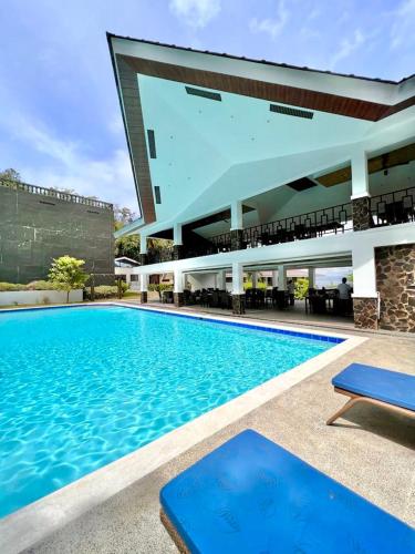a large swimming pool in front of a building at Amor Laut in Mabini