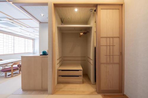 a closet with a wooden door in a room at Hotel Isago Kobe in Kobe