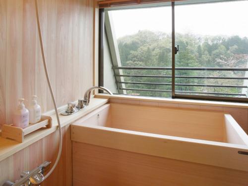 a bathroom with a bath tub next to a window at Hotel Oyanagi in Tagami