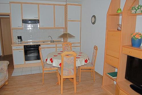 a kitchen with a table and chairs in a room at Seepferdchen in Dorum Neufeld