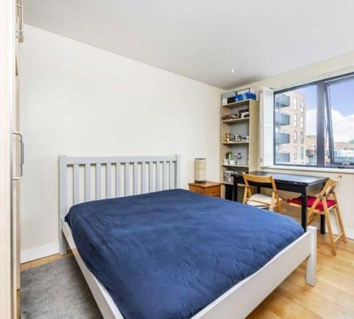 a bedroom with a bed and a desk and a window at Juicey apartments in London