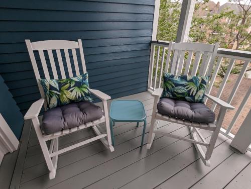 two rocking chairs with pillows sitting on a porch at The 1890 Freeman House in Galveston