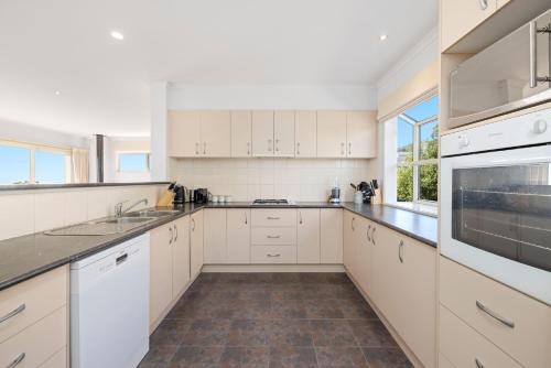 a kitchen with white cabinets and a sink and a microwave at Sunset Views - Cozy McCrae Getaway in McCrae