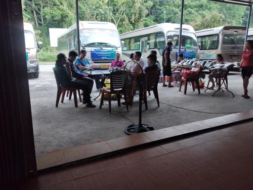 a group of people sitting at tables in front of buses at Thành Luân Hotel in Bak Kan