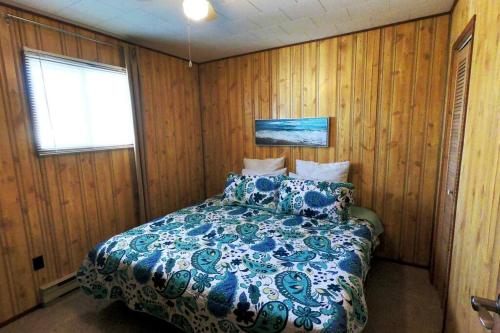a bedroom with a bed in a room with wooden walls at Peaceful & Private Cabin close to the Lake in Matlock