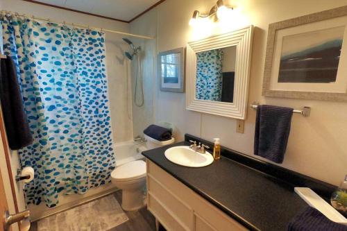 La salle de bains est pourvue d'un lavabo, de toilettes et d'une douche. dans l'établissement Peaceful & Private Cabin close to the Lake, à Matlock