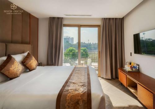 Ngon Avatar Hotel في بلاي كو: غرفة نوم بسرير كبير ونافذة كبيرة