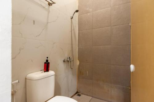 a bathroom with a toilet and a shower at RedDoorz At Jalan Asia Medan in Medan