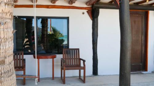 two chairs and a table in front of a window at Choby's House Holbox in Holbox Island