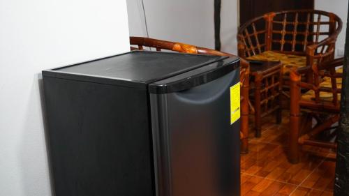 a black refrigerator with a yellow sticker on it at Choby's House Holbox in Holbox Island