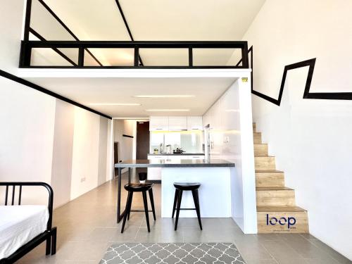 a loft apartment with a staircase and a kitchen at KL Sentral Serviced Apartment - The Establishment KL Sentral by Loop Suites in Kuala Lumpur