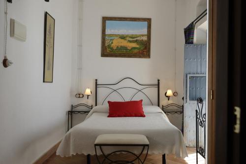 um quarto com uma cama com uma almofada vermelha em Casa Rural Las Cadenas del Cananeo em Arcos de la Frontera