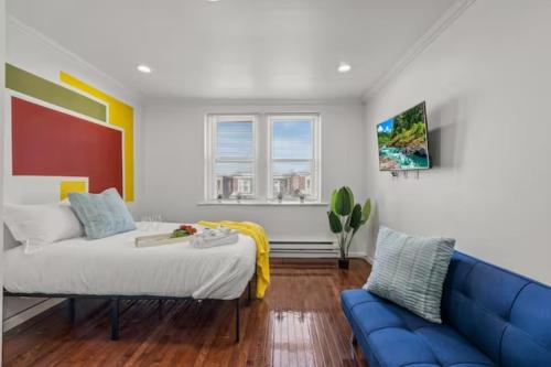 a bedroom with a bed and a blue couch at Cozy&Chic Apartments Near Downtown in Philadelphia