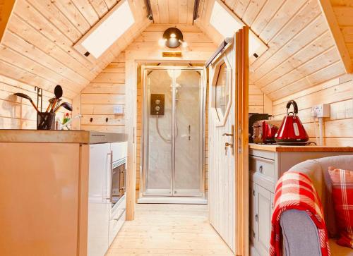 a small kitchen with a shower in a tiny house at Seal Cove Cabin - Luxury Glamping in Cairndow
