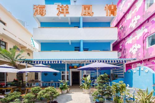 a colorful building with umbrellas in front of it at Ocean B&B in Xiaoliuqiu