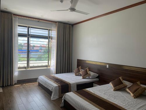 a hotel room with two beds and a window at Khách sạn Ánh Trăng in Lạng Sơn