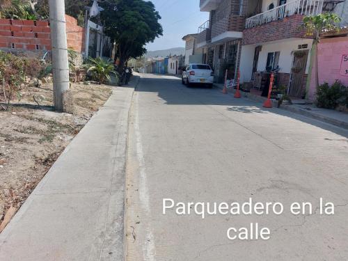 an empty street with a car driving down the road at Tranquilo Apartamento Central Cerca a la Playa Puerto Colombia in Puerto Colombia