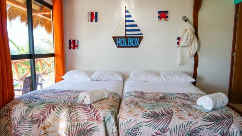 a bedroom with two beds and a sign on the wall at Choby's House Holbox in Holbox Island