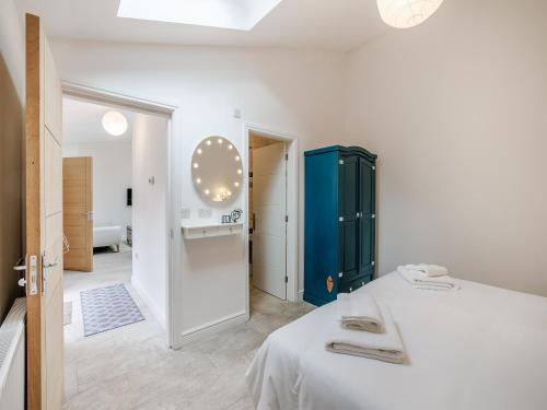 ein Schlafzimmer mit einem weißen Bett und einem blauen Schrank in der Unterkunft Alexander Z - Uk43586 in Ellesmere