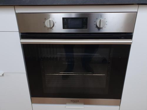 a black oven with a clock on top of it at 2 pièces lumineux aux portes de Paris in Clamart