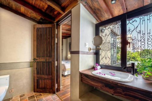 een badkamer met een wastafel en een raam met een bad bij Maycasa Villa - Private pool 4BR in Da Nang