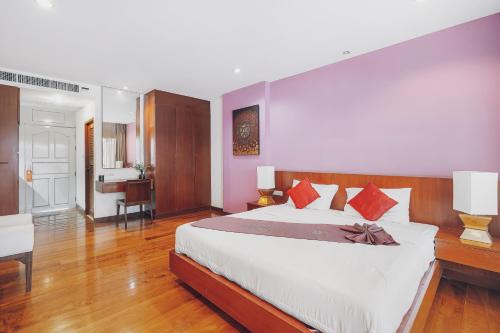 a bedroom with a large bed and a desk at The Dale Pattaya Boutique and Spa in Pattaya South