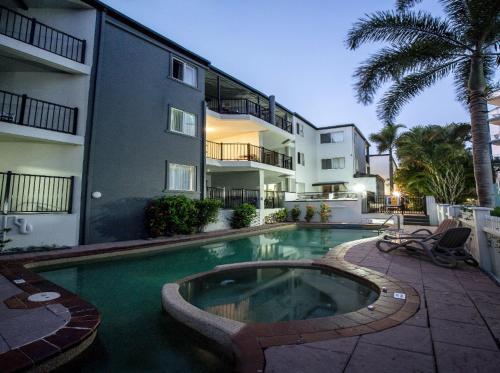 a swimming pool in front of a building at Stunning 2 BR, 2 Bathroom Beachfront Apartment Close To Everything! in Hervey Bay