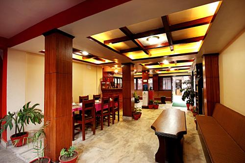 ein Esszimmer mit einem Tisch und einigen Pflanzen in der Unterkunft Hotel Bubo Himalaya in Kathmandu