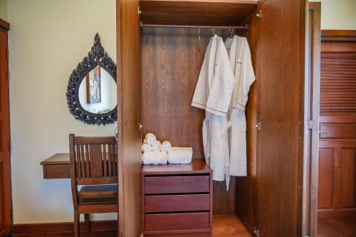 a closet with a wooden door and a mirror at มนต์เมืองเชียงใหม่ รีสอร์ต Monmuang Chiangmai Resort in Hang Dong