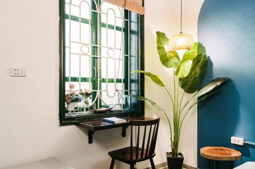 Cette chambre comprend une table, un miroir et une plante. dans l'établissement Anchie Home Lý Nam Đế- Ha Noi Train Street- Ha Noi Old Quarter, à Hanoï