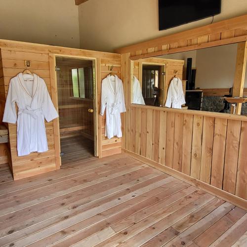 a room with wooden walls and wooden floors and white robes at La Martinelle in Maurs