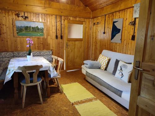 een woonkamer met een bank en een tafel bij Beehive cabin on a farm in Radovljica