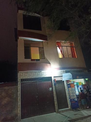 una casa por la noche con dos ventanas y un garaje en Casa Mimaya dpto301 en Piura