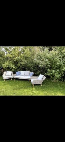 two chairs and a couch sitting in the grass at Haus am Hügel in Oberkühberg